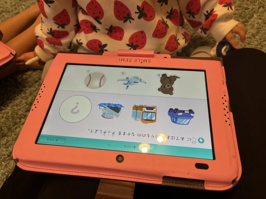 スマイルゼミのタブレットに、絵の中から同じ音で始まる言葉を選ぶ問題が表示されている。野球ボールや飛行機、バスなどのイラストが並ぶ